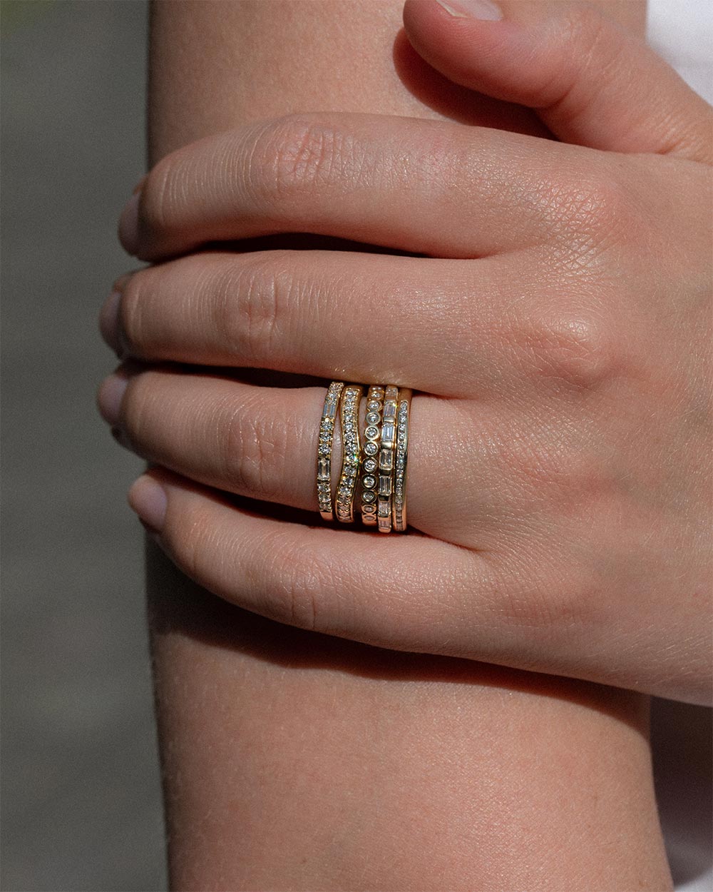 Model wearing 18 Ct gold Platinum Diamond Contour Ring and 4 other gold rings.