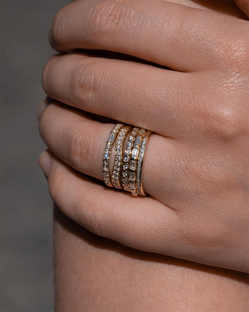 18ct Yellow Gold Bezel Diamond Half Eternity Ring displayed on model with 3 more rings