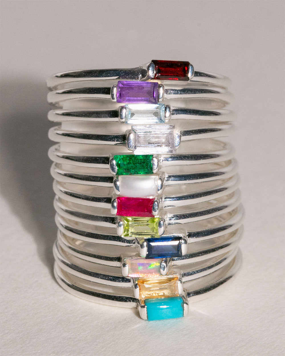 stack of sterlign silver birthstone rings including March Aquamarine Birthstone Baguette Ring