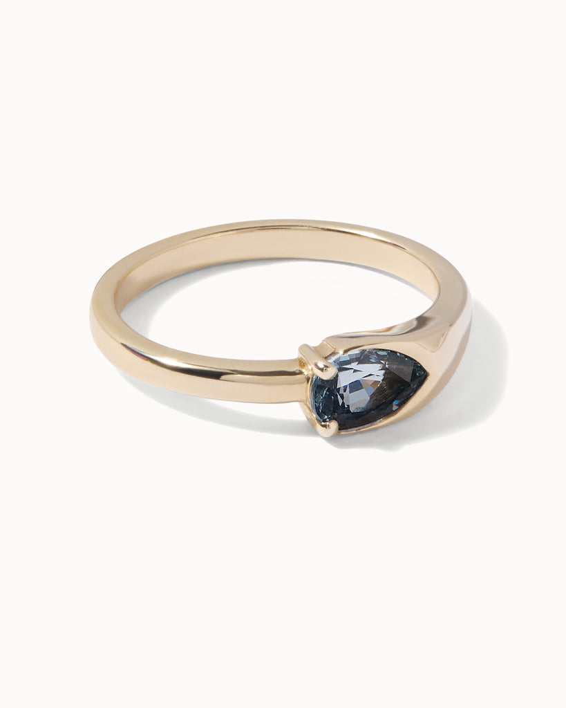 solid gold solitaire engagement ring featuring a radiant pear-cut sapphire handcrafted by Maya Magal London