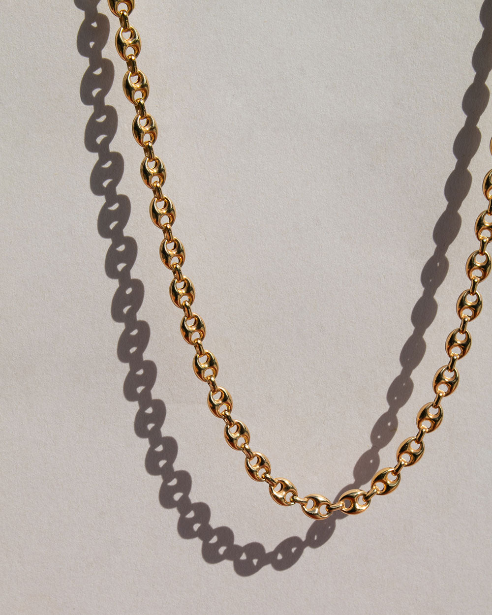 An anchor chain on a hwite background with a shadow.