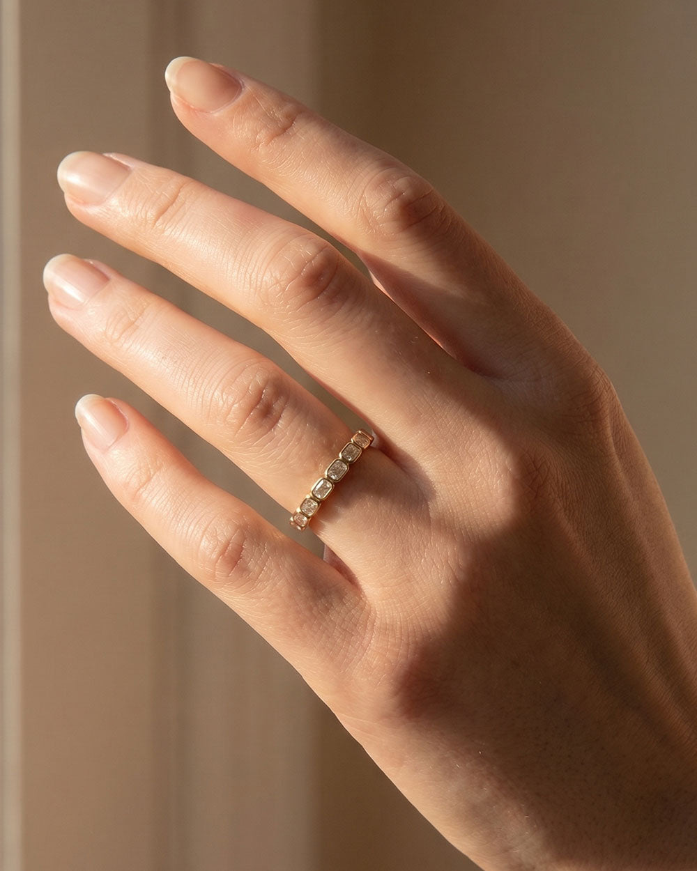 9ct Yellow Gold East-West Bezel Diamond Eternity Ring displayed on model