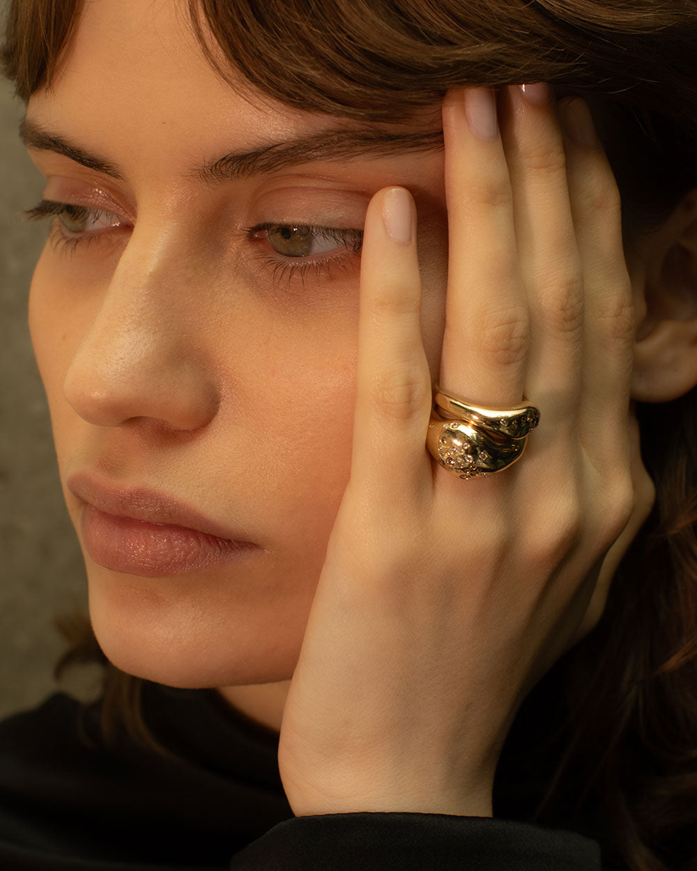 Model wearing organic statement solid gold celestial ring with flush set ethically sourced champagne and white diamonds.