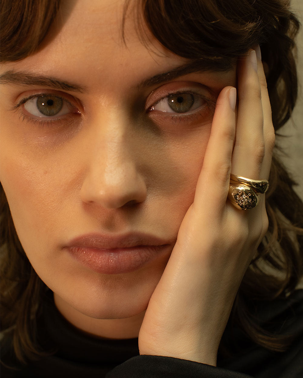 Model wearing organic statement solid gold celestial ring with flush set ethically sourced champagne and white diamonds.