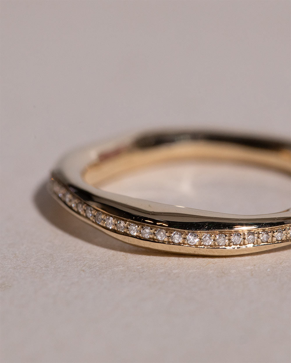 Upclose photo of 9ct solid gold Helios Pavé Eternity Ring on white backgorund.