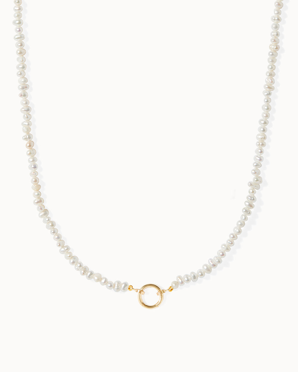 Milos necklace adorned with freshwater pearl beads and delicate gold charms, by Maya Magal London.