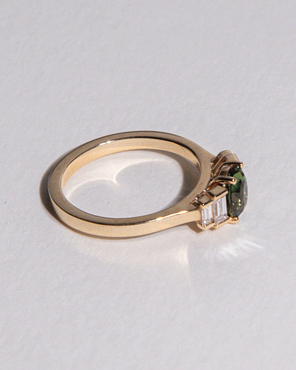 side view photo of 9 Ct solid gold Nina 1.22ct Green Sapphire Ring on white background