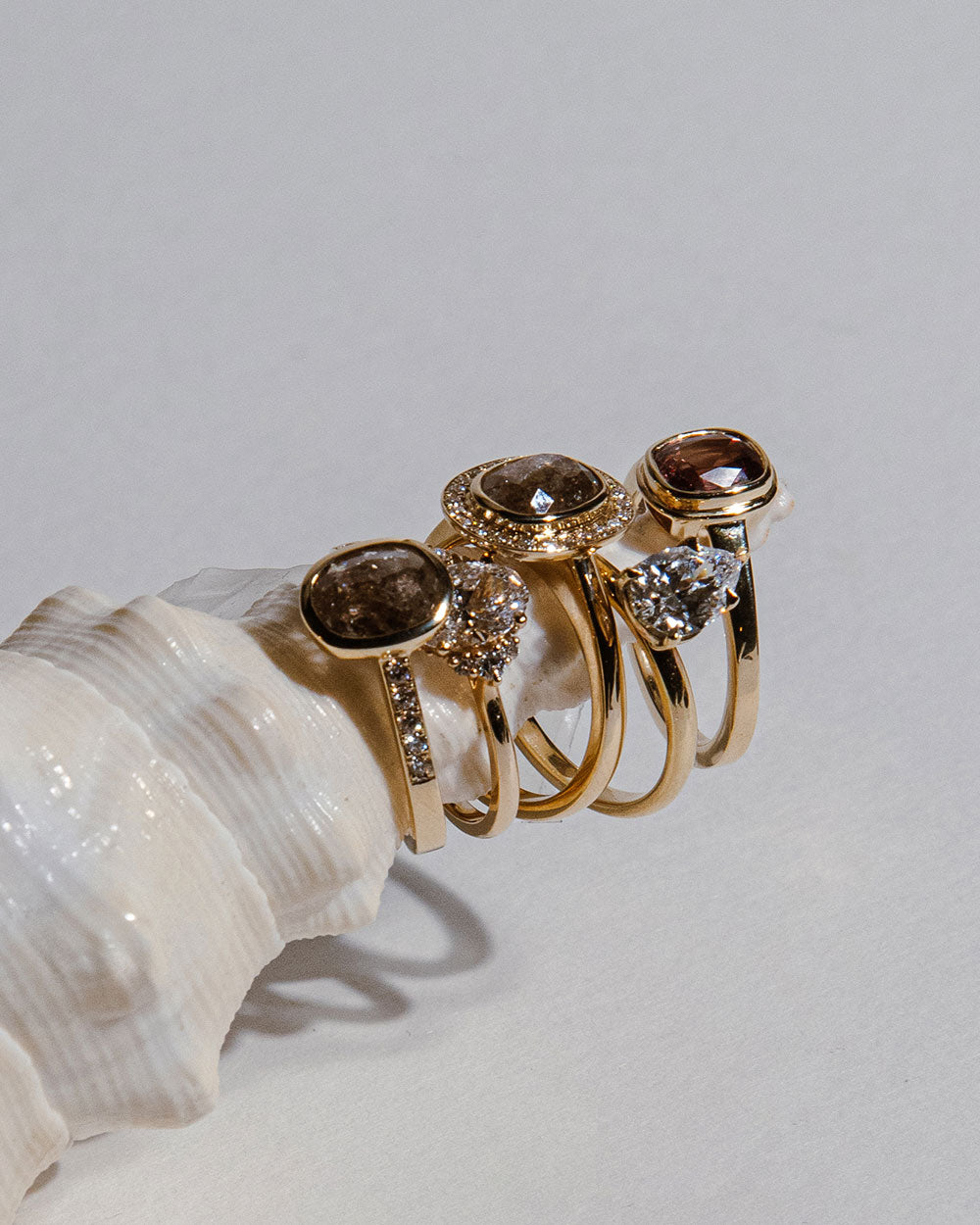 9 Ct solid gold Nieve 1.2ct Grey Diamond Ring displayed with 4 other rings on sea shell