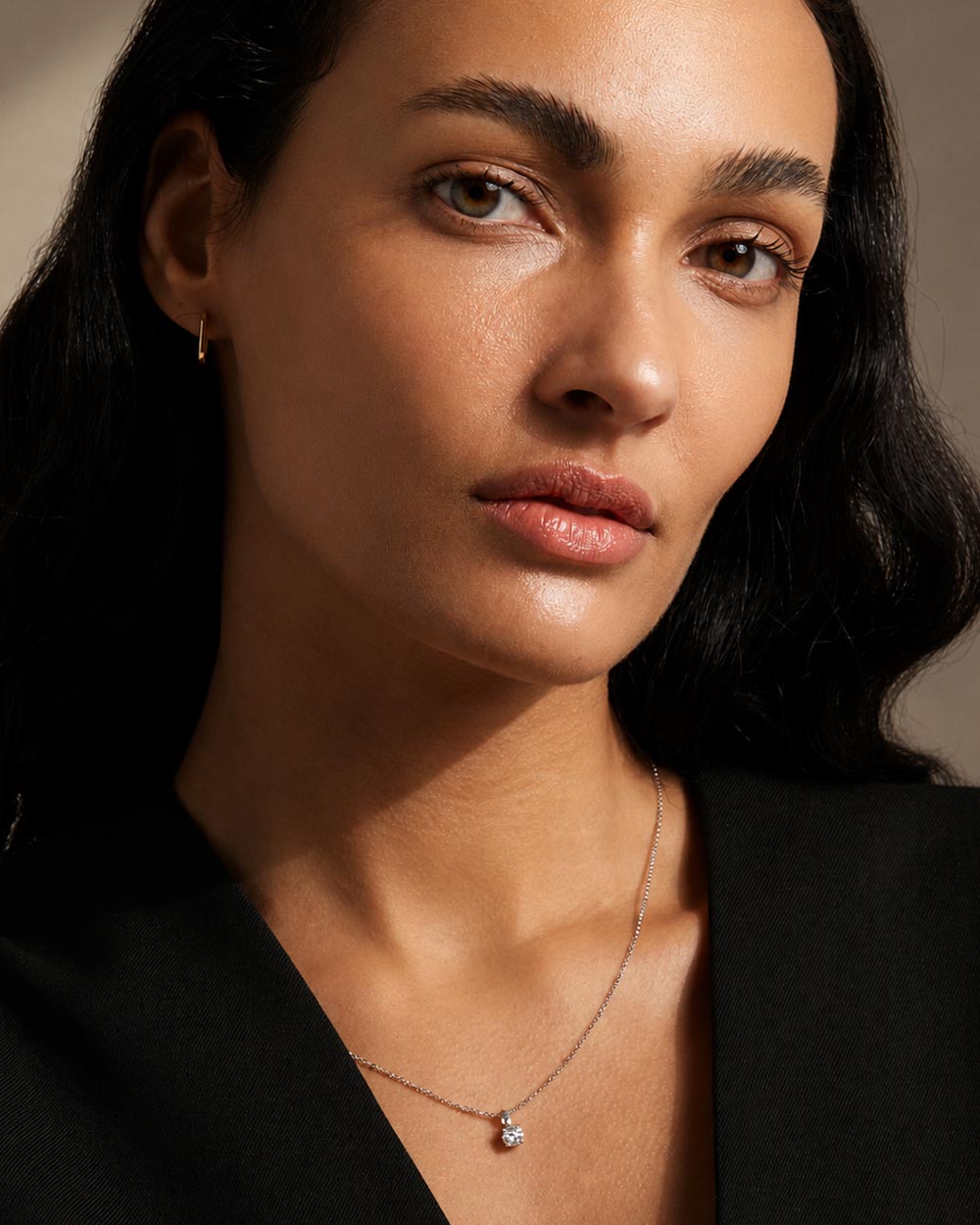Front view of model wearing solid gold hoop earrings