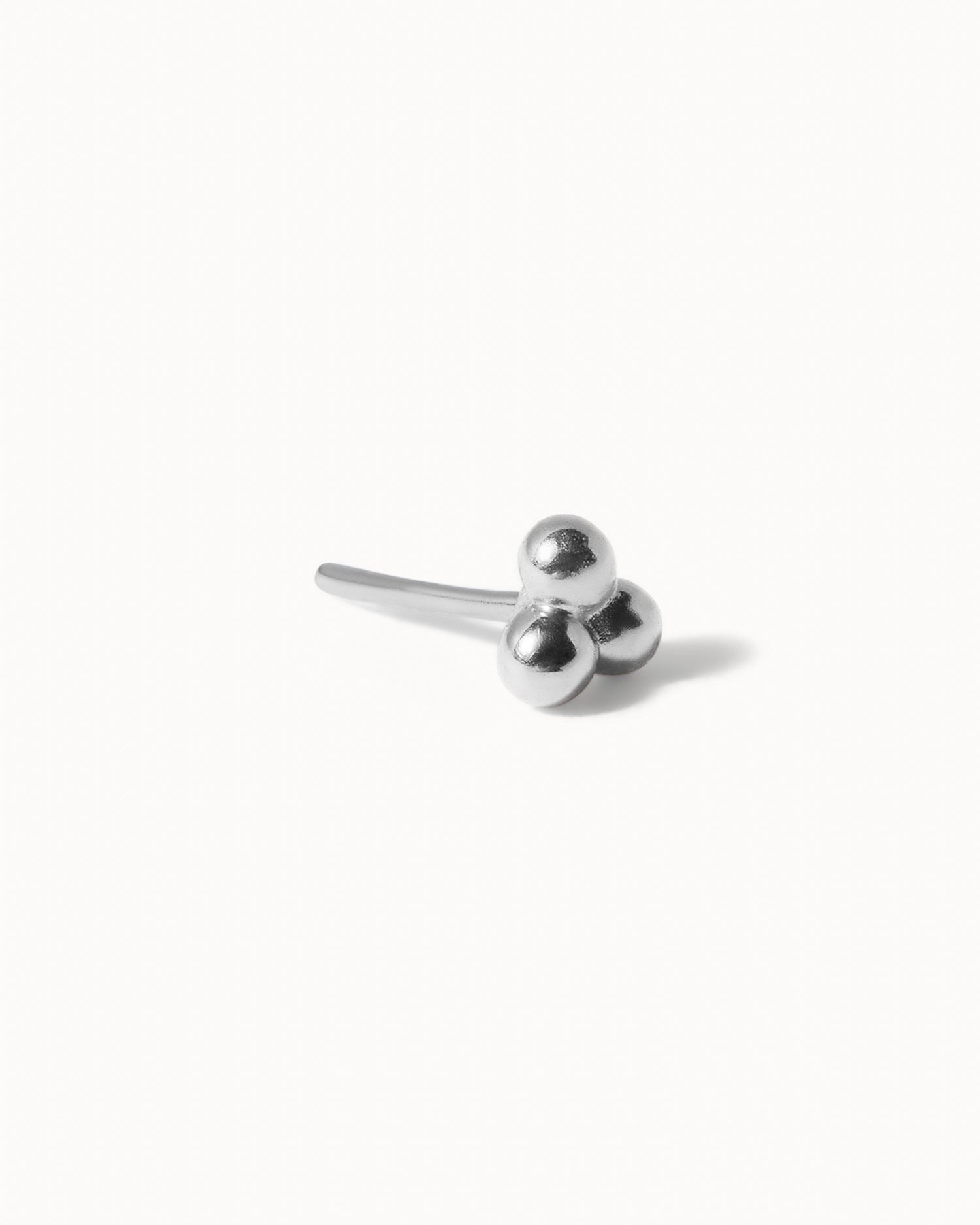 Side view of white gold stud earring of white background.