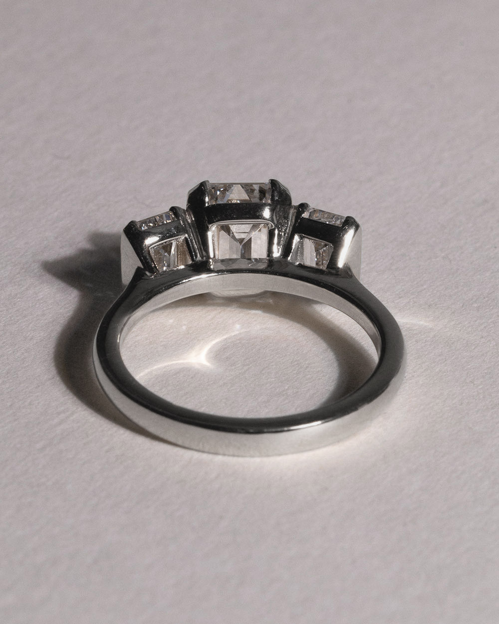 Platinum Emerald Cut Lab Grown Diamond Trilogy Ring back view on white background