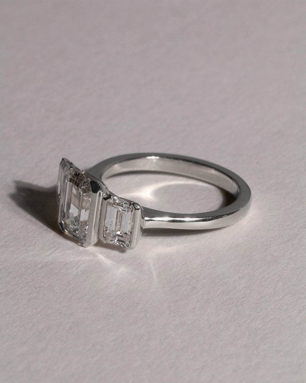 Platinum Emerald Cut Lab Grown Diamond Trilogy Ring front side view on white background