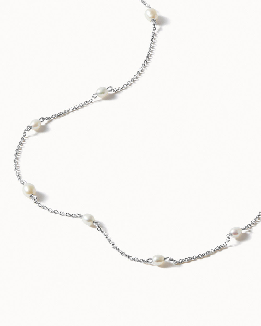 Silver chain Pearl necklace on a white background