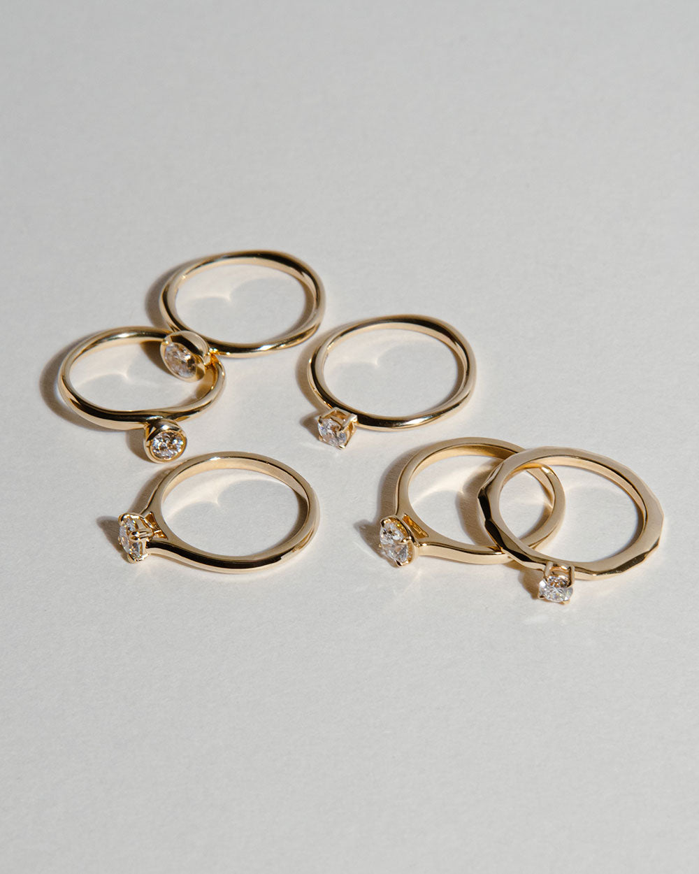 display of scattered wings on white backdrop including 0.5ct Lab Grown Diamond Bezel Ring with 9 Ct solid gold band
