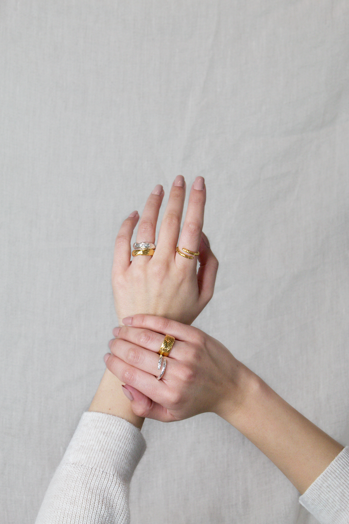 maya magal stacking rings on woman's hands against white backdrop