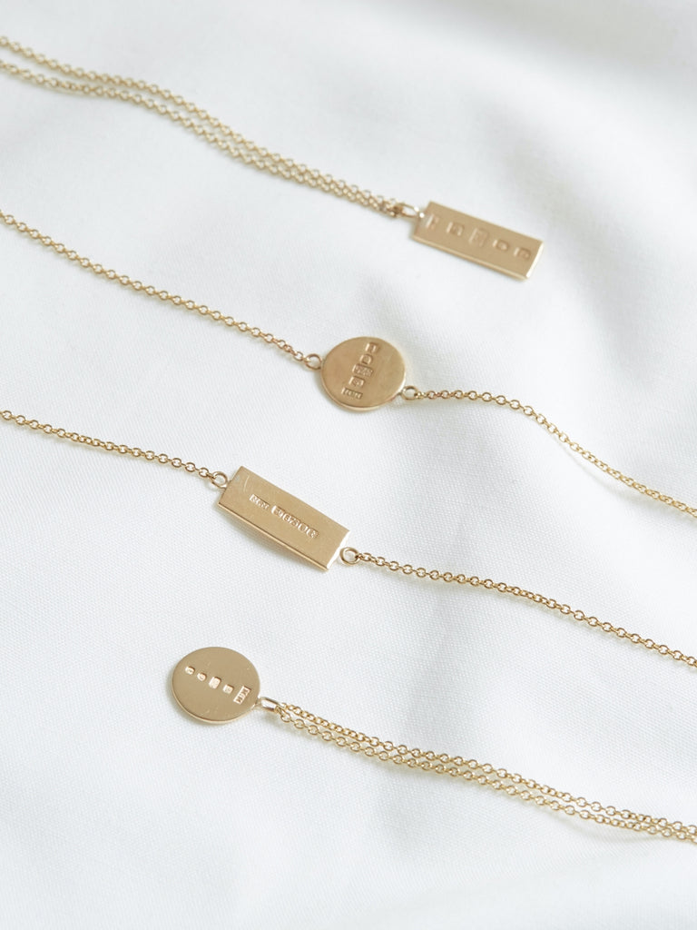solid gold chain necklaces lined up against a white background