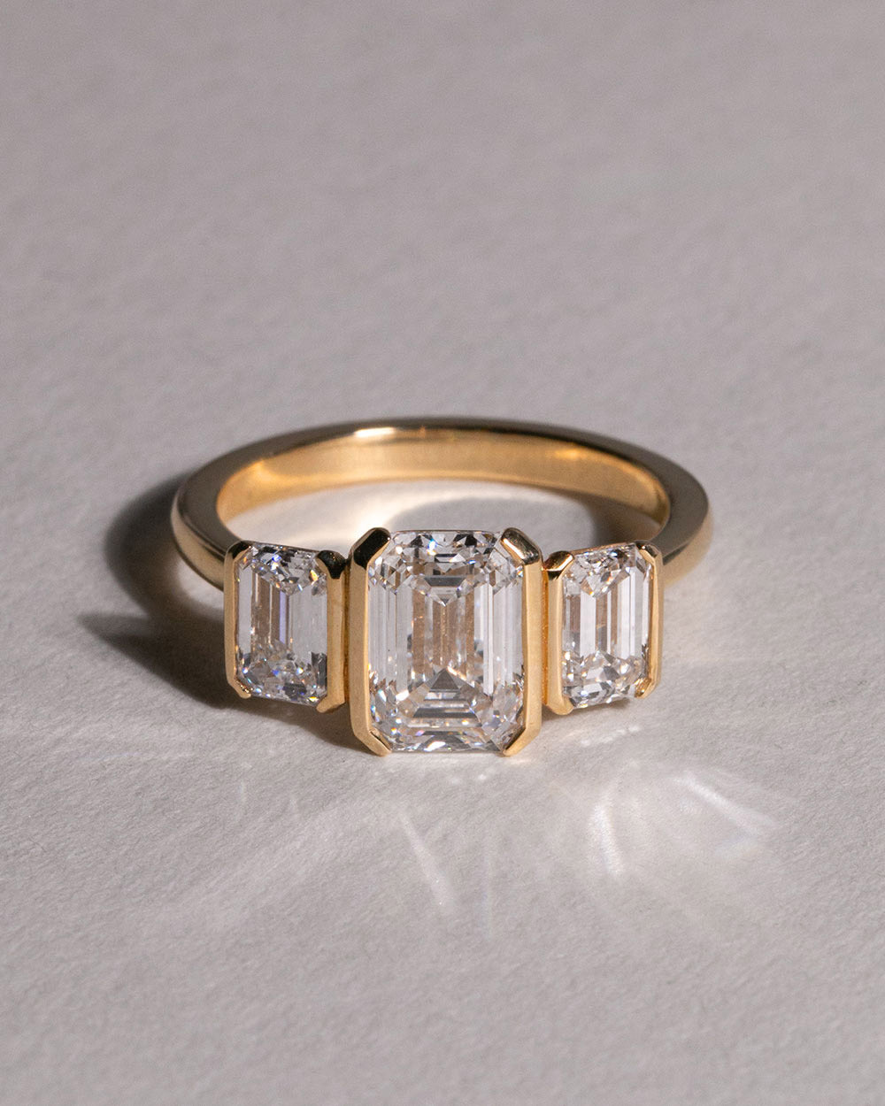 18ct Gold Emerald Cut Lab Grown Diamond Trilogy Ring front view on white background