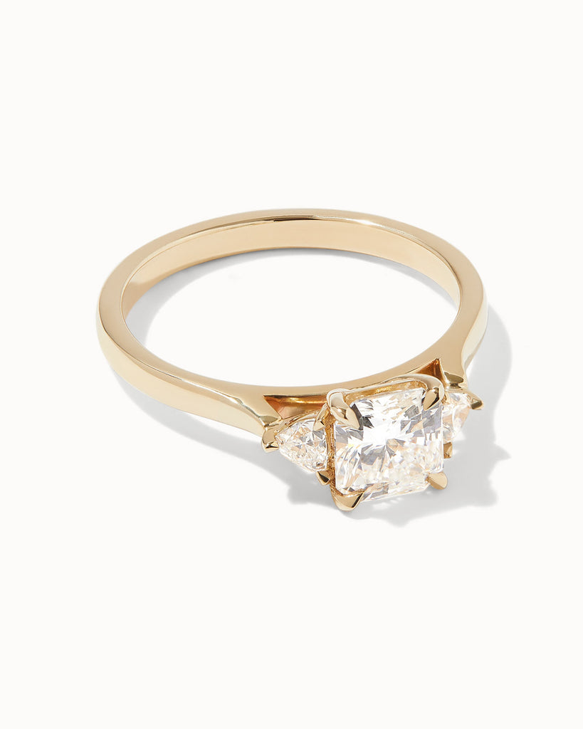 Radiant Cut white diamond with Trillion side stones set on a recycled 9ct solid yellow gold band handcrafted in London by Maya Magal