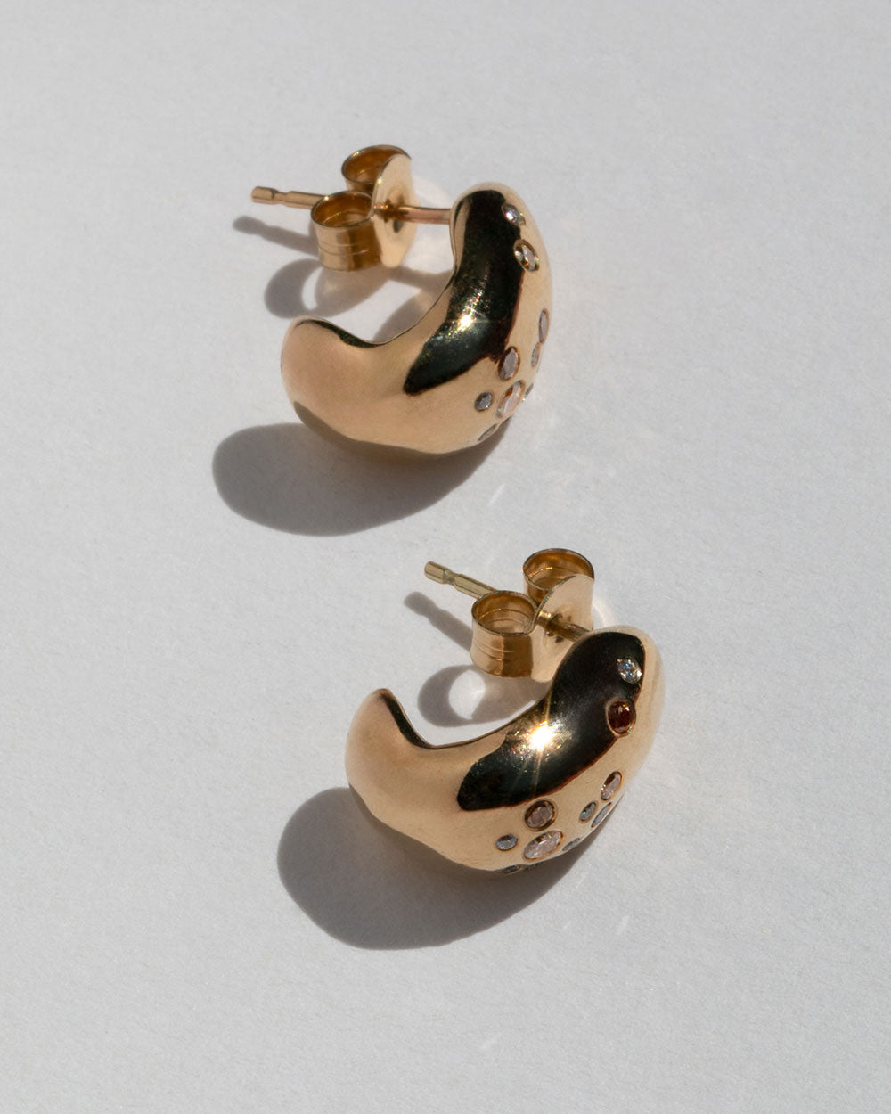 side view 9ct solid yellow gold hoop earrings with flush set champagne, grey and white diamonds. 