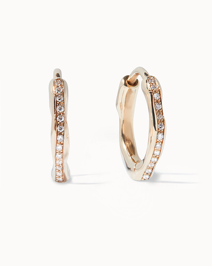 Fluid and organic 9ct solid gold huggie hoops adorned with sparkling pave set diamonds. Our Helios earrings are handcrafted in our London workshop.