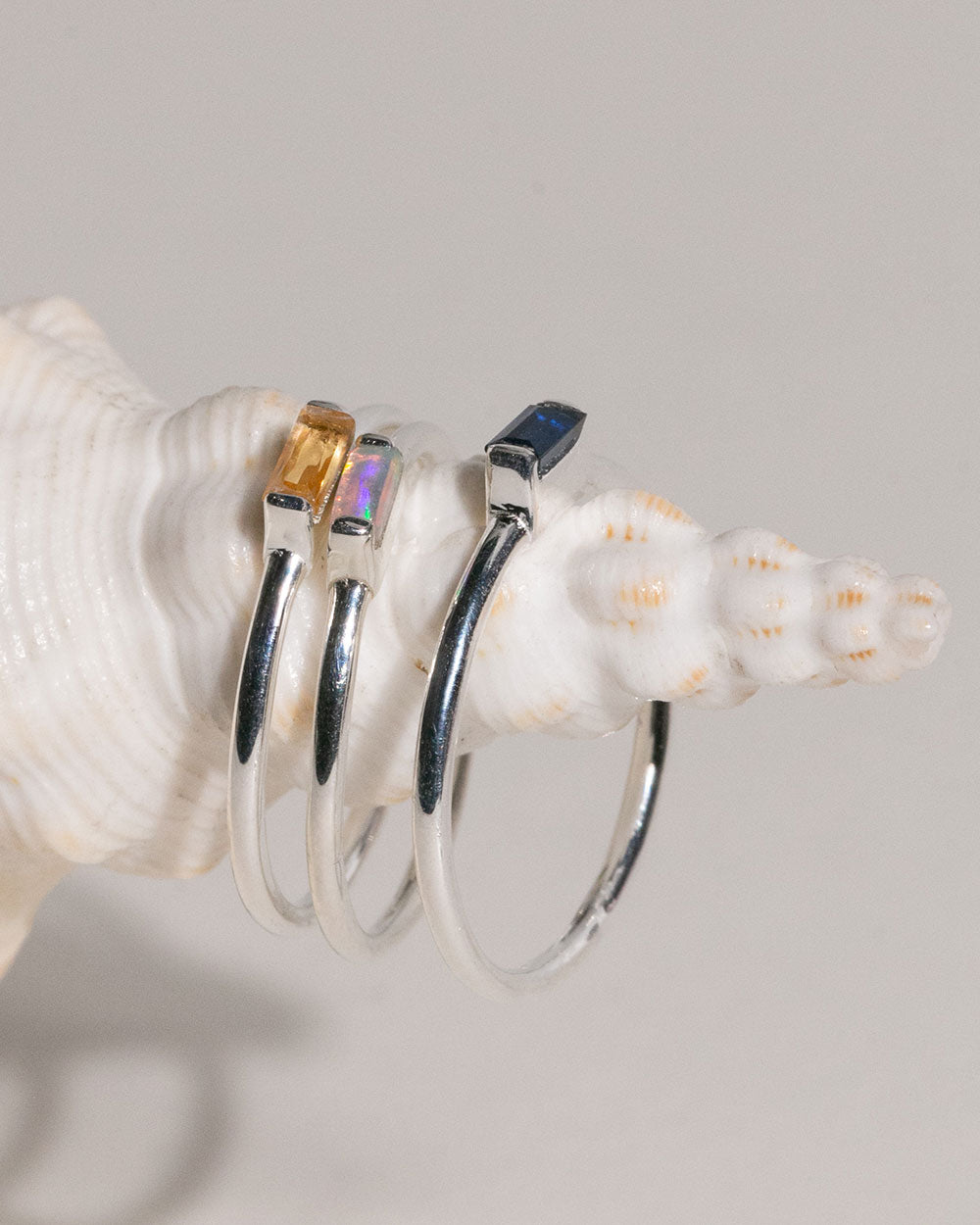 October Opal Birthstone Baguette Ring displayed on shell