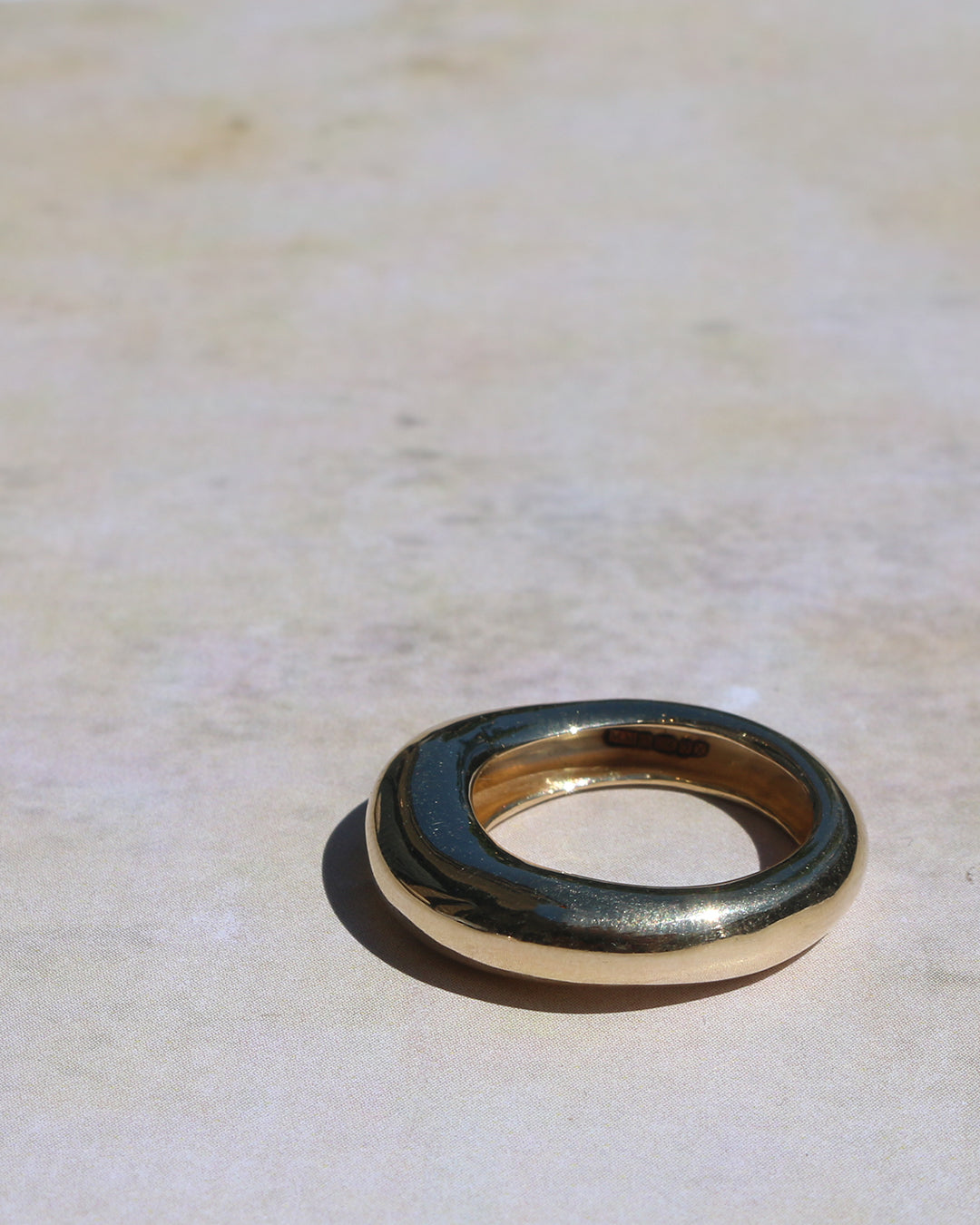9ct solid gold chunky ring on textured background.