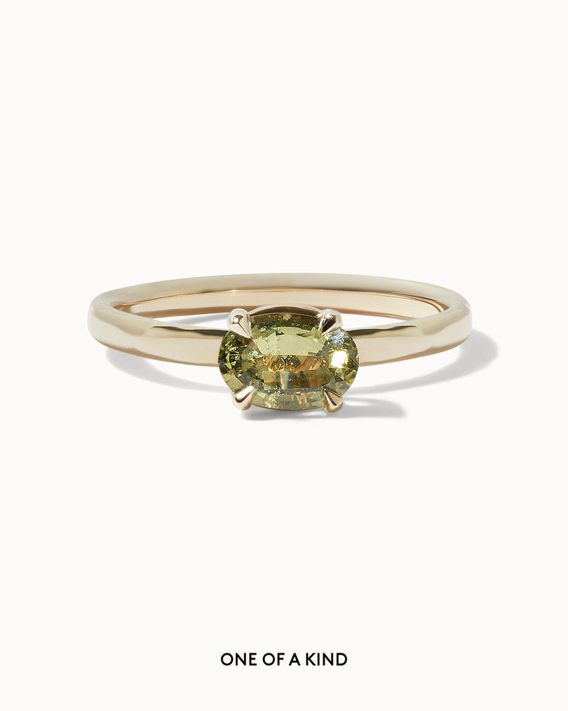 solid gold solitaire engagement ring featuring a light green oval sapphire by Maya Magal London