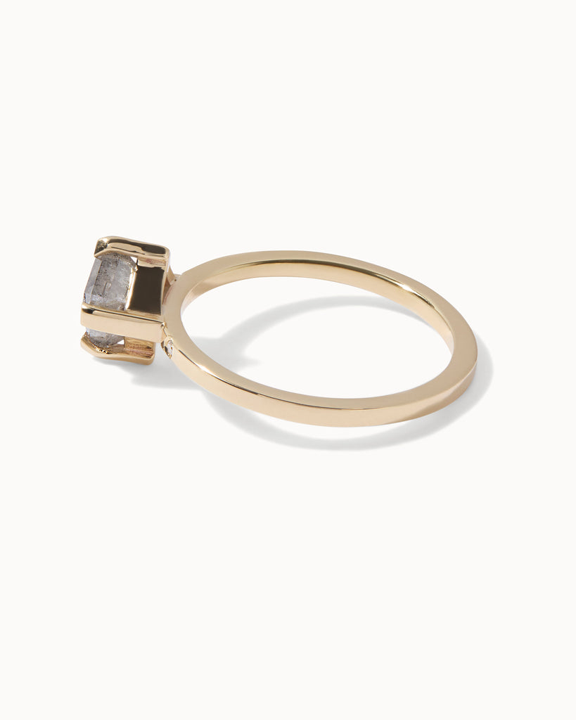 solid gold engagement ring featuring a rectangle cut grey diamond set on a contemporary flat band, studded with bezel set white diamonds handcrafted in London by Maya Magal London