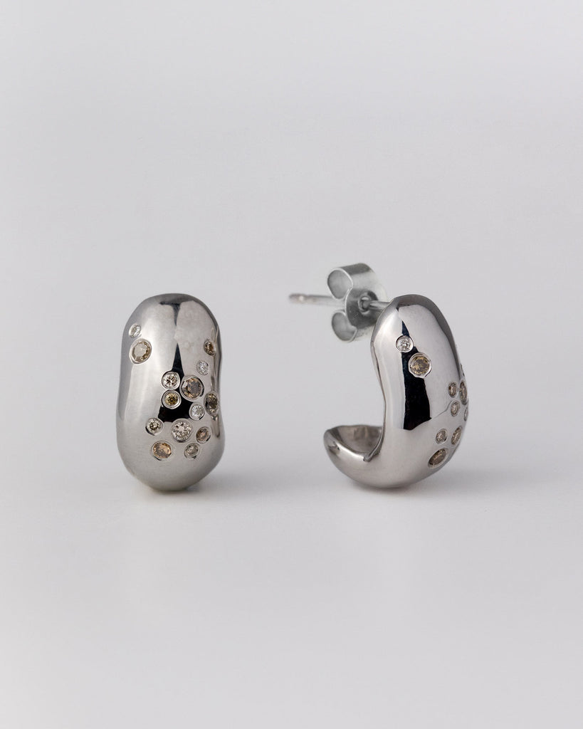 Recycled 9ct solid white gold sculptural hoop earrings with finely set white and champagne natural diamonds handcrafted in London by Maya Magal London