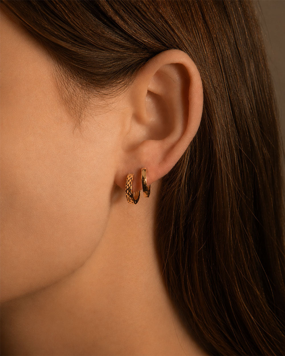 9 CT gold Hexagon Hoop Earrings  displayed with one other earring on model 