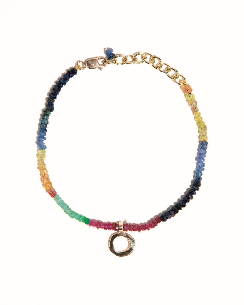 sapphires, emeralds and rubies beaded bracelet handstrung on silk thread handcrafted in London with 9ct solid gold organic charm by Maya Magal London