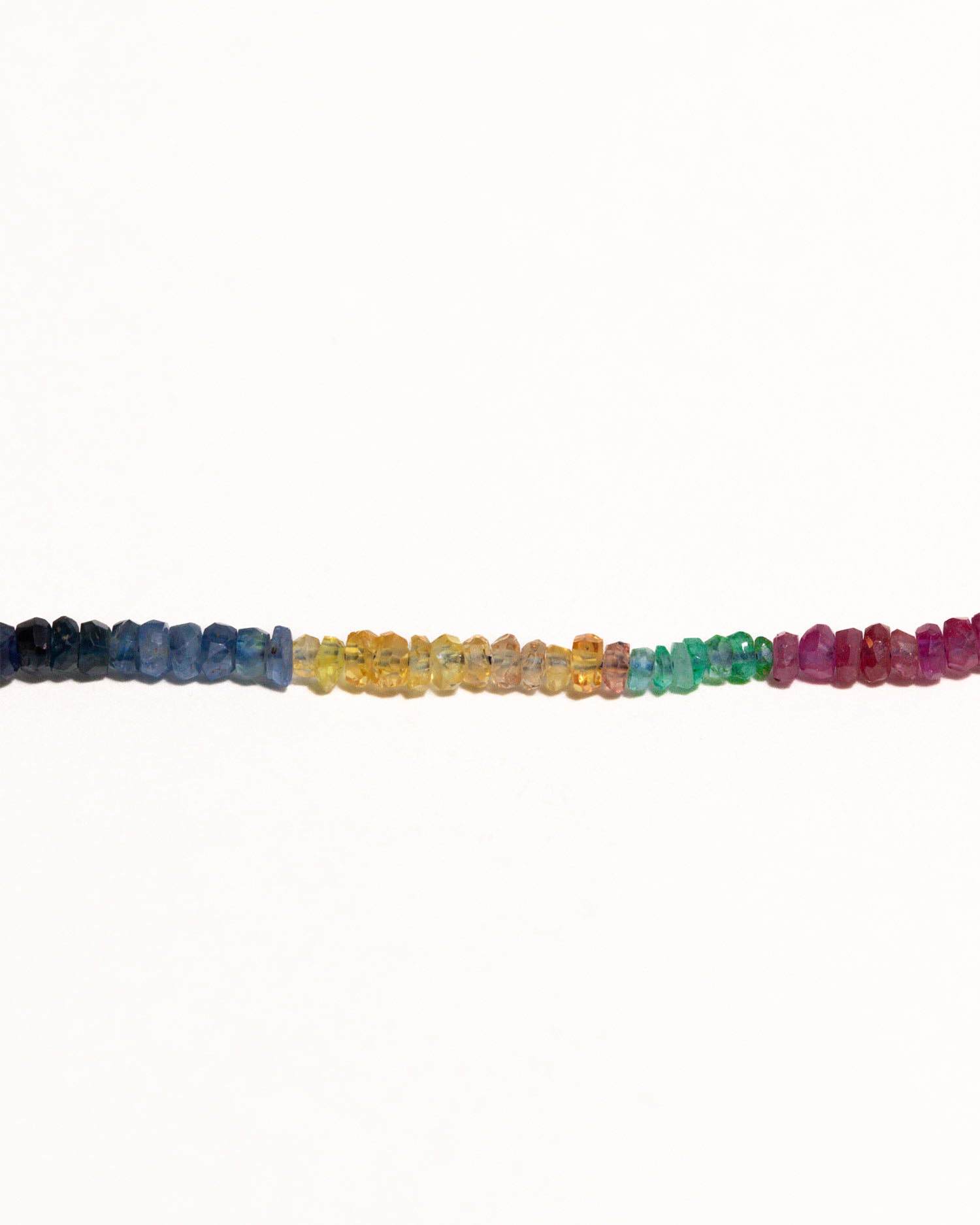 sapphires, emeralds and rubies beaded necklace handstrung on silk thread handcrafted in London with 9ct solid gold organic charm by Maya Magal London