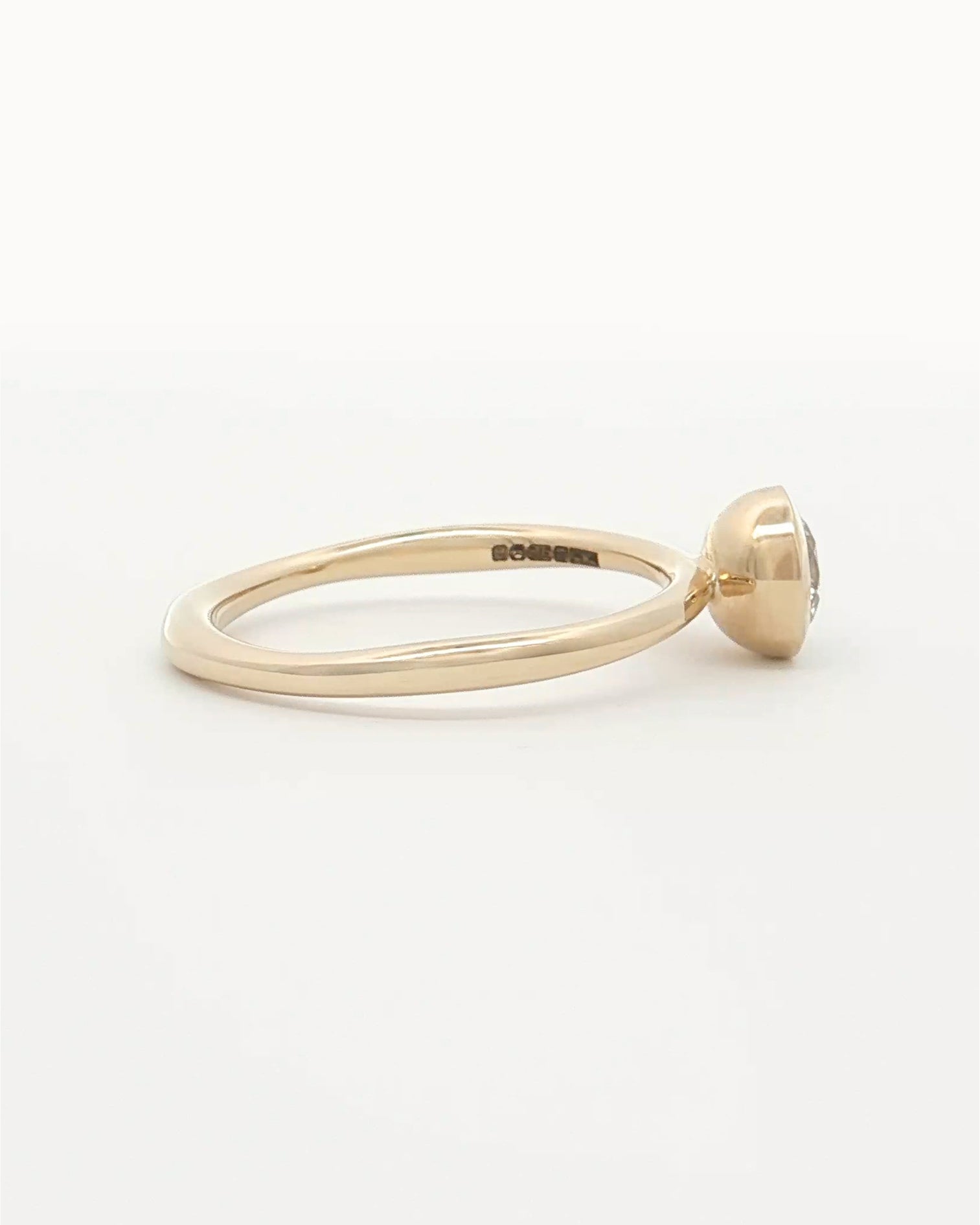 side view of 0.5ct Lab Grown Diamond Bezel Ring with 9 Ct solid gold band on white backdrop