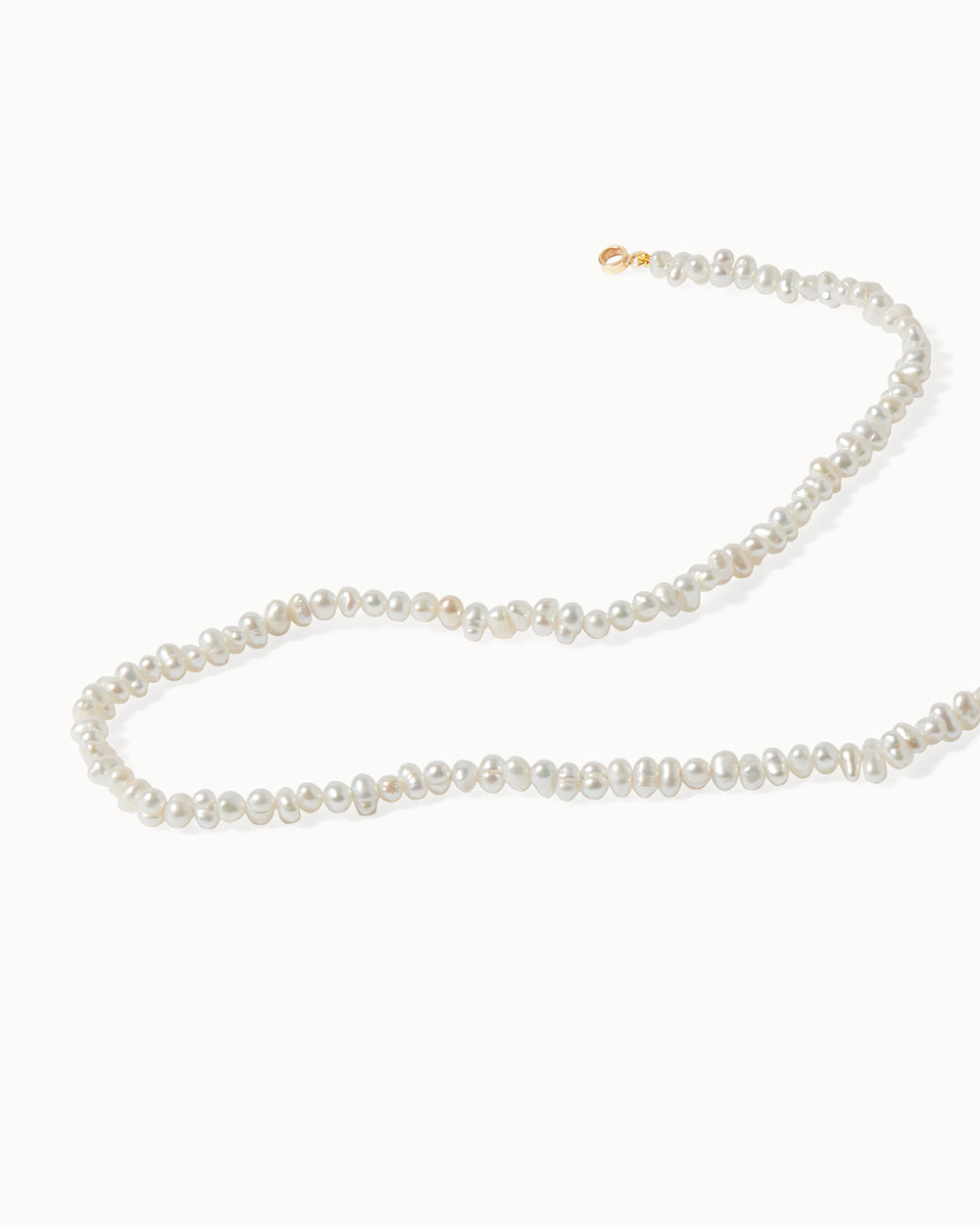 Elegant pearl beaded Milos charm necklace featuring solid gold accents, handcrafted by Maya Magal London.
