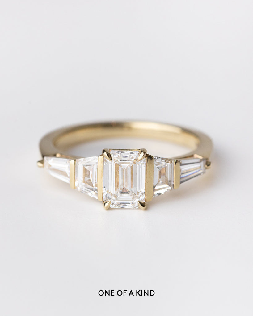 Emerald cut lab grown diamond with trapezoid and tapered baguette side stones ring set in a recycled 9 ct solid yellow gold band handcrafted in London by Maya Magal