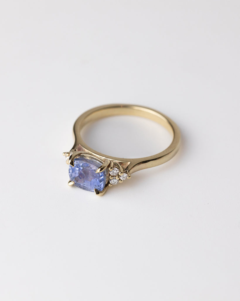 Cushion cut Sapphire with natural round side diamonds ring set in a recycled 9 ct solid yellow gold band handcrafted in London by Maya Magal