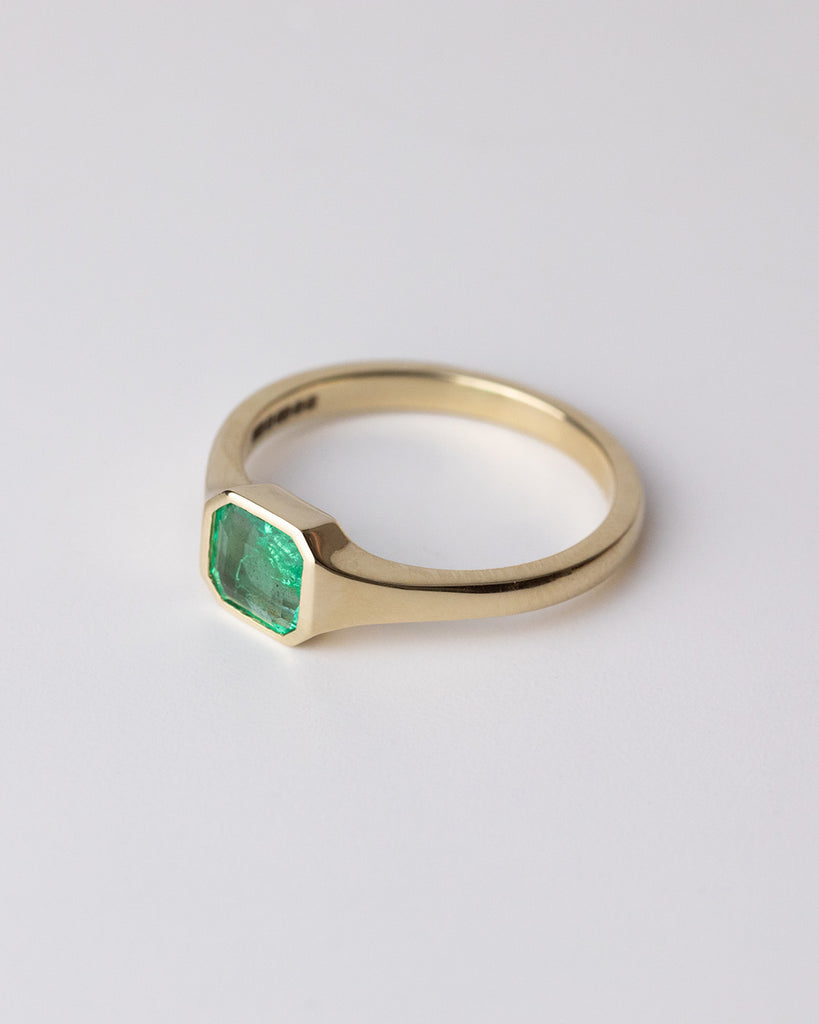 Emerald cut Emerald solitaire ring set in a recycled 9 ct solid yellow gold band handcrafted in London by Maya Magal