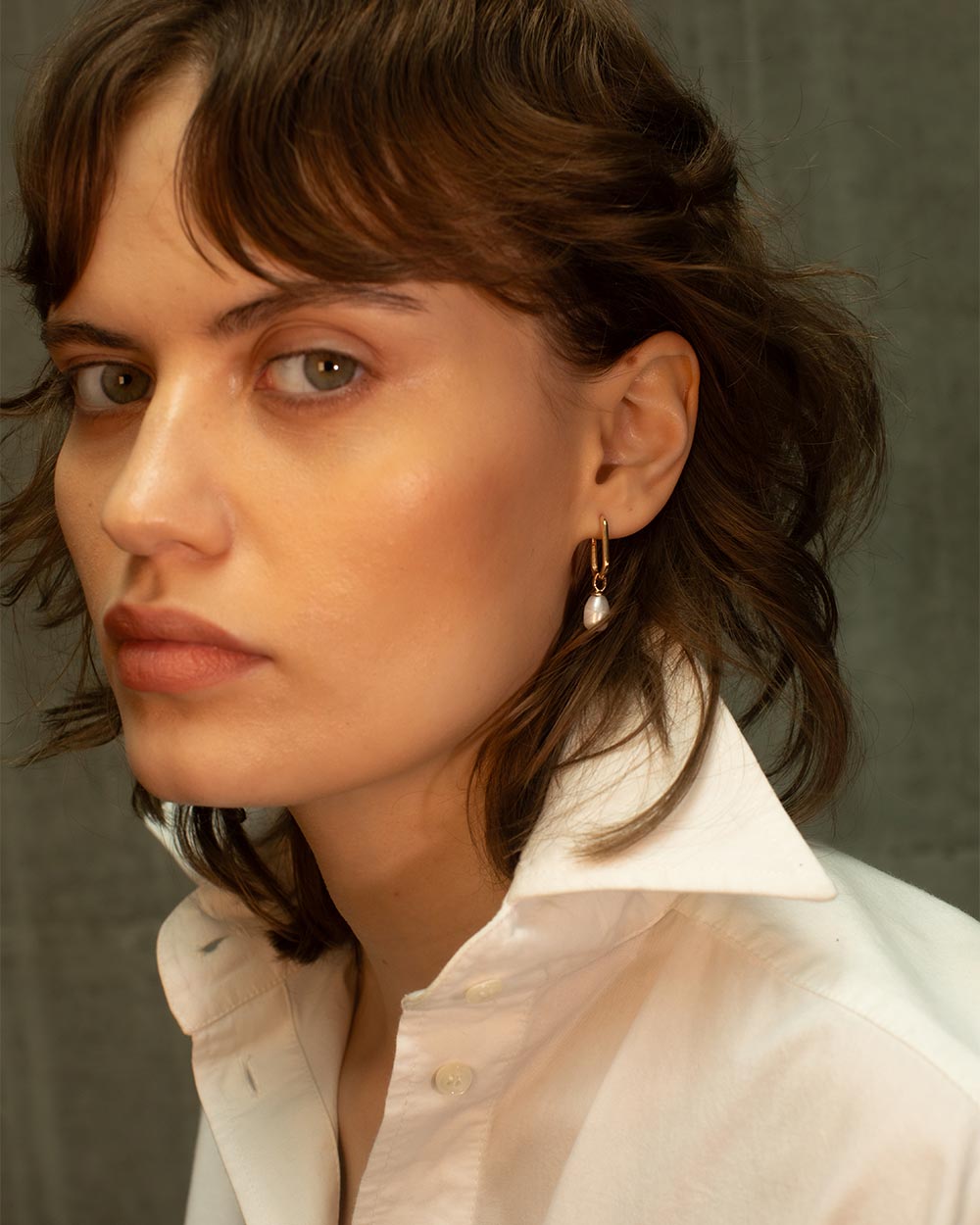 Woman wearing a white shirt with a neutral background