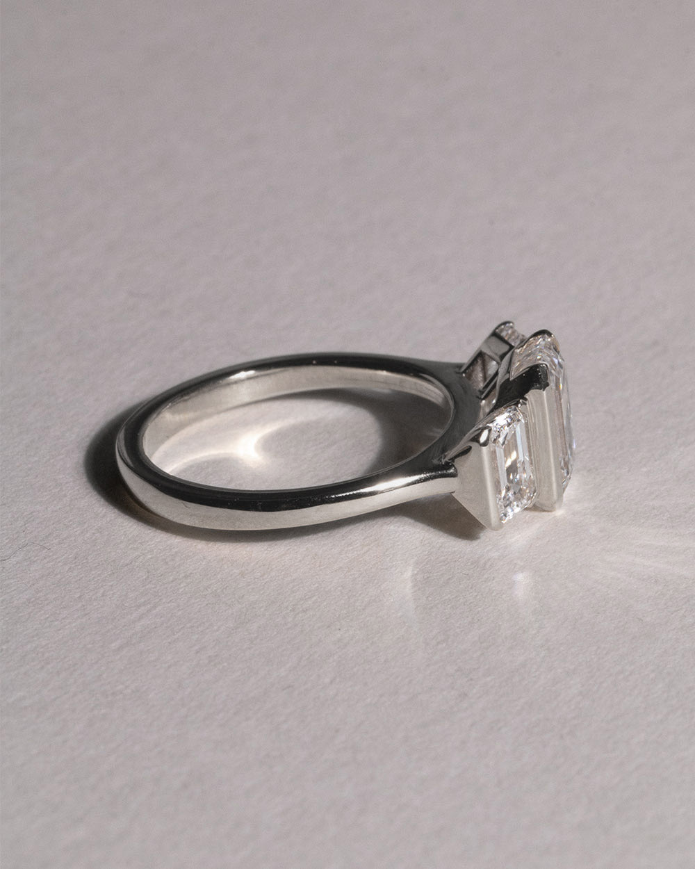 Platinum Emerald Cut Lab Grown Diamond Trilogy Ring side view on white background