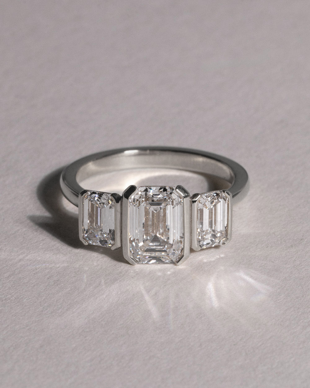 Platinum Emerald Cut Lab Grown Diamond Trilogy Ring front view on white background