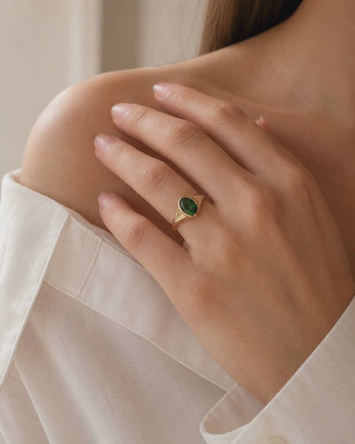 Video of model wearing 9ct gold Ring with 0.78ct oval-cut Tanzanian green tourmaline, chosen for its rich, vibrant colour and natural character. Flush-set signet design on a white background.
