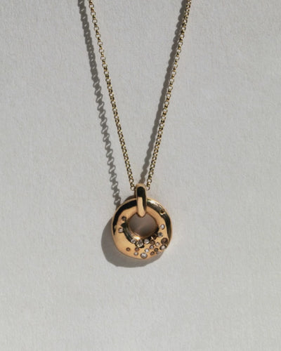 Video of 9 ct solid gold necklace with circular charm flush set with grey champage and white diamond.