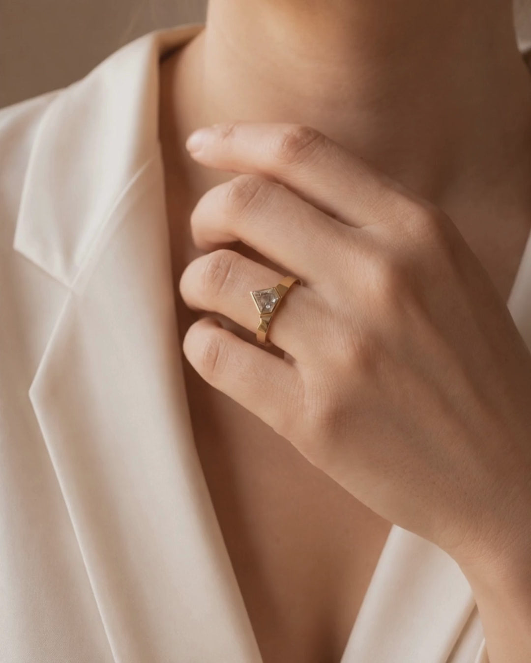 Video of model wearing 9ct solid recycled gold ring with 0.59ct fancy shield-cut salt and pepper diamond, with natural markings that make the stone entirely individual. Set in a clean bezel setting, its geometric shape sits neatly against a simple flat band. Made sustainably in London.
