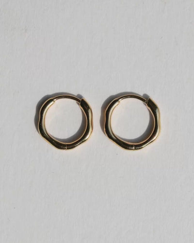 Video of single solid gold huggie hoop earring. 