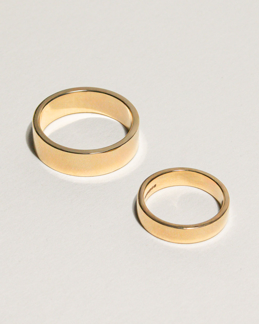 18ct Yellow Gold Signature Band Ring displayed with larger band