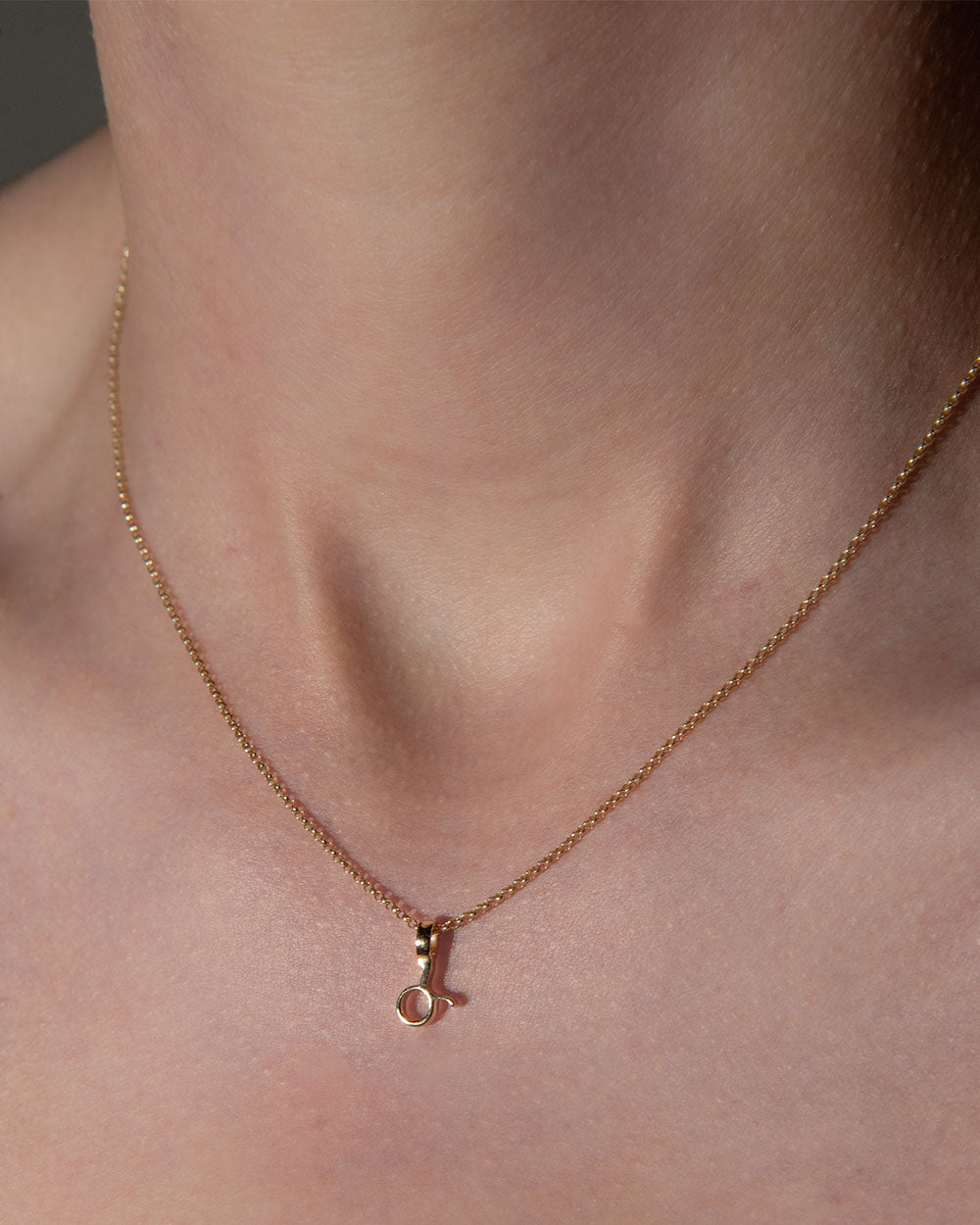 gold taurus Zodiac Charm on chain worn by model 