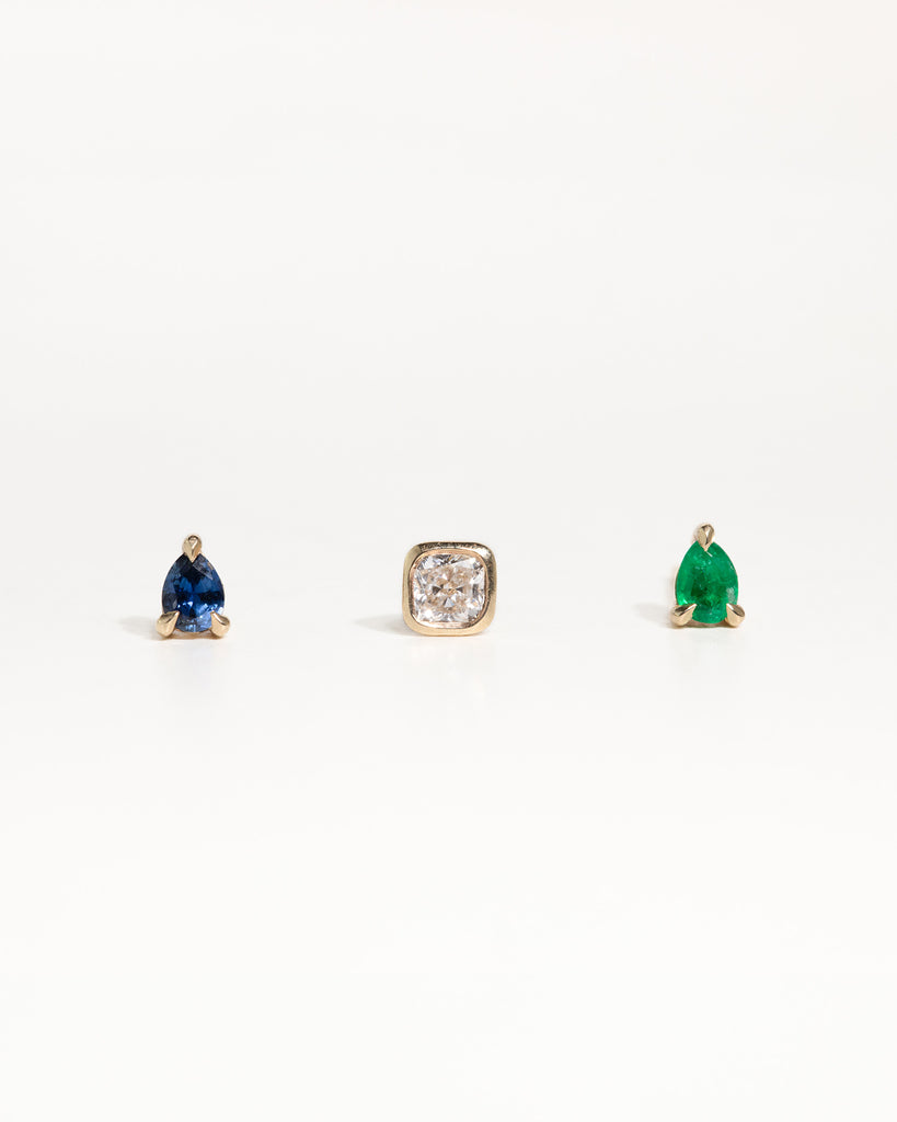 pear cut natural emerald stud earring encased in recycled solid gold handcrafted in London by Maya Magal London