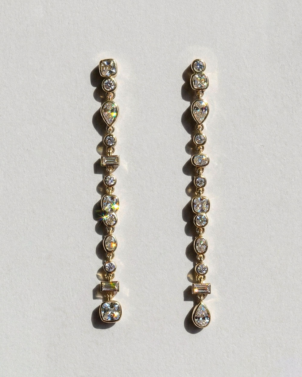 Gold Vega Diamond Drop Earrings on white background.